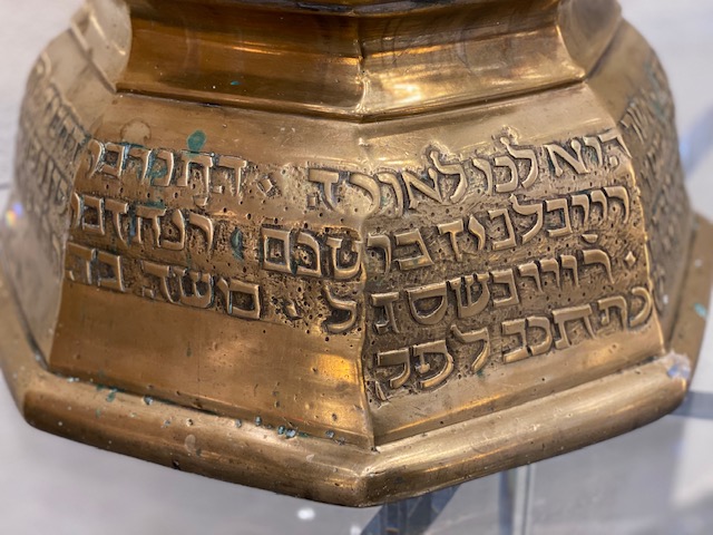 A close up of the lettering on a gold colored object.